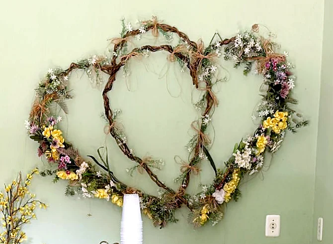 Detalhe do arranjo de flores secas e coloridas em forma de dois corações entrelaçados